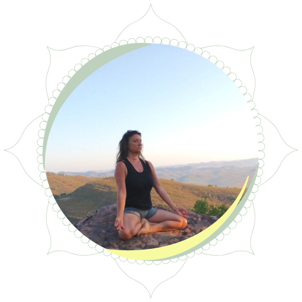 woman sat in lotus yoga position in the mountains with the sun rising behind her.