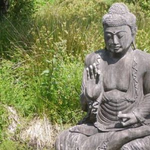 stone yoga statue in lotus position in meditation at a peaceful yoga retreat in Cornwall